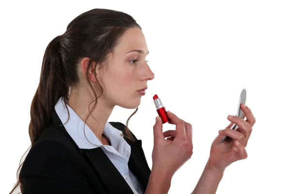 Ung kvinna som använder läppstift — Stockfoto