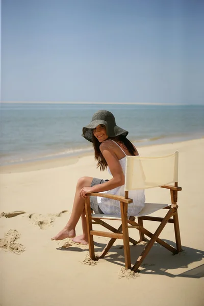 Жінка сидить на пляжному стільці — стокове фото