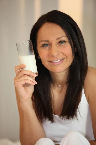 Donna con bicchiere di latte in mano — Foto Stock
