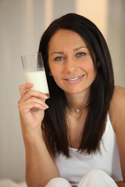 Vrouw met glas melk in hand — Stockfoto