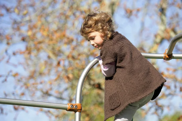 Petite fille jouant sur le cadre d'escalade — Photo