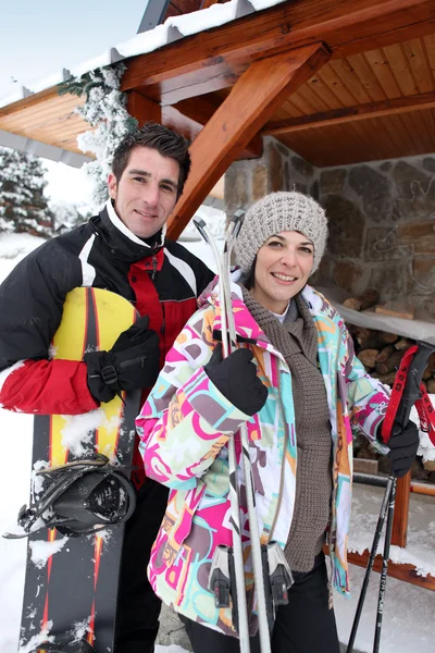 Couple stood outside holiday chalet — Stock Photo, Image