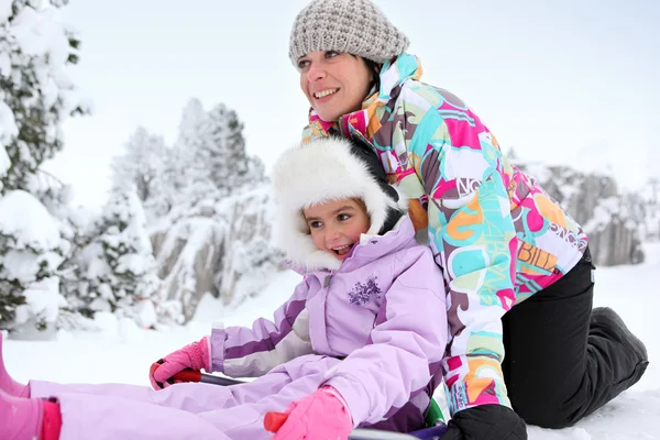 Mãe e filha brincando na neve juntos — Fotografia de Stock
