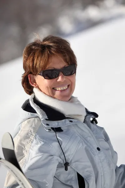 Glückliche Frau mittleren Alters, die durch den Schnee geht — Stockfoto