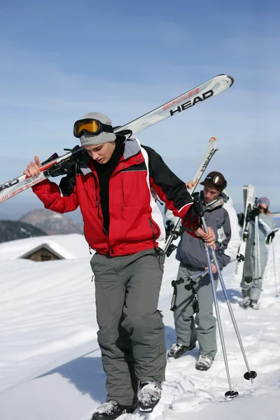 Юноши с лыжами на плечах — стоковое фото