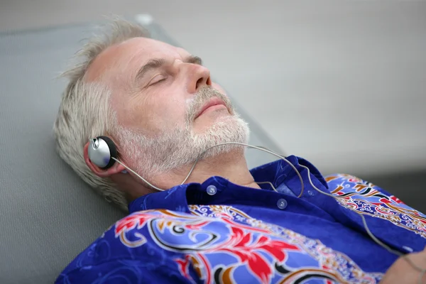 Senior ontspannen en luisteren muziek — Stockfoto