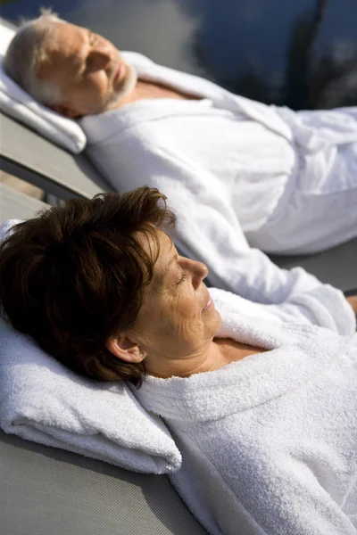 Äldre par på semester bär badrockar — Stockfoto