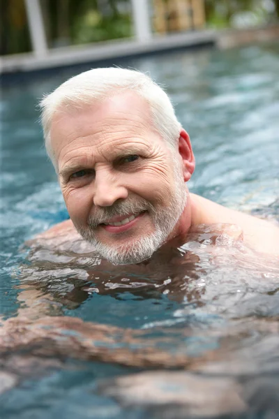 Grijs-haired mens zwemmen in het zwembad — Stockfoto