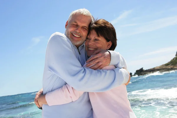 Married couple hugging by the sea — Stock Photo, Image