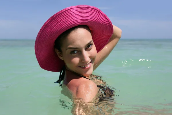 Mulher de chapéu rosa na praia — Fotografia de Stock