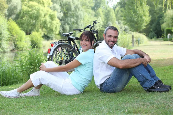 Coppia seduta con biciclette — Foto Stock