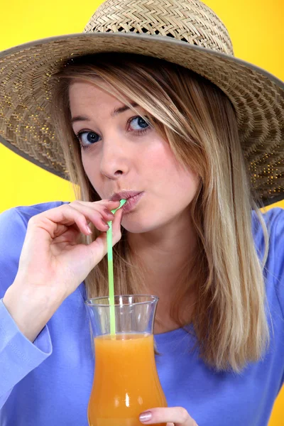 Жінка п'є сік через соломинку — стокове фото