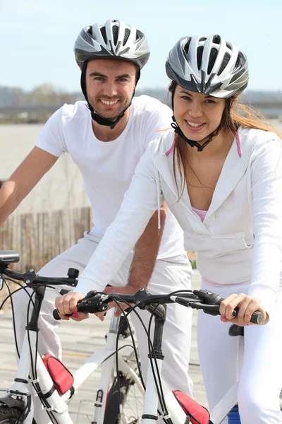 Couple in white on a bicycle — Stock Photo, Image