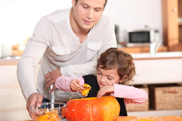 Father with daughter emptying pumpkin — Stock Photo, Image