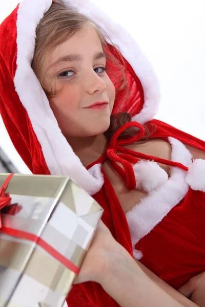 Liten flicka i en santa outfit med jul presenterar — Stockfoto
