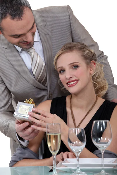 A woman at restaurant receiving a gift — Stock Photo, Image