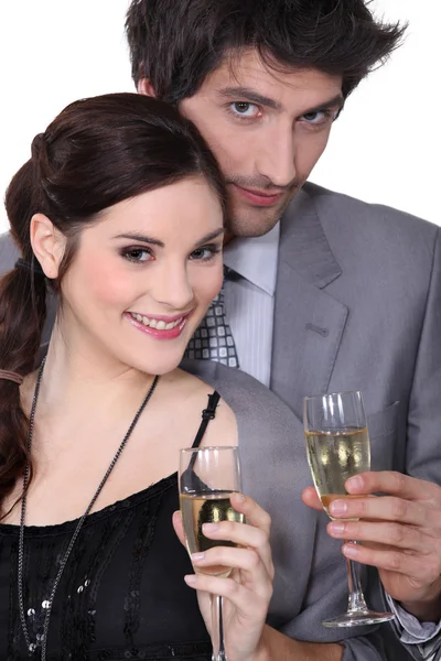 Young man and woman smiling holding champagne glasses — Stock Photo, Image