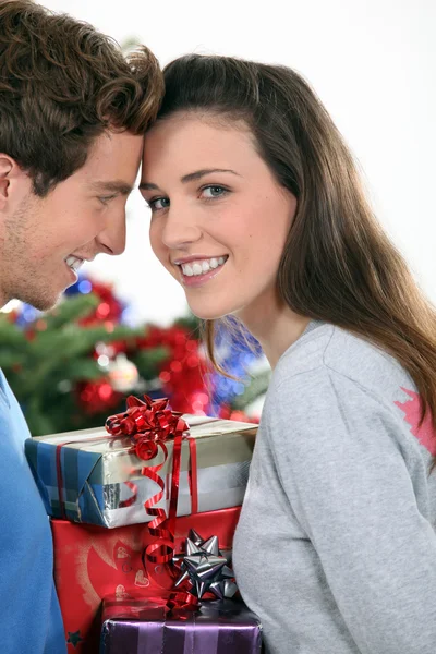 Couple se tenait près de l'arbre de Noël et cadeaux — Photo