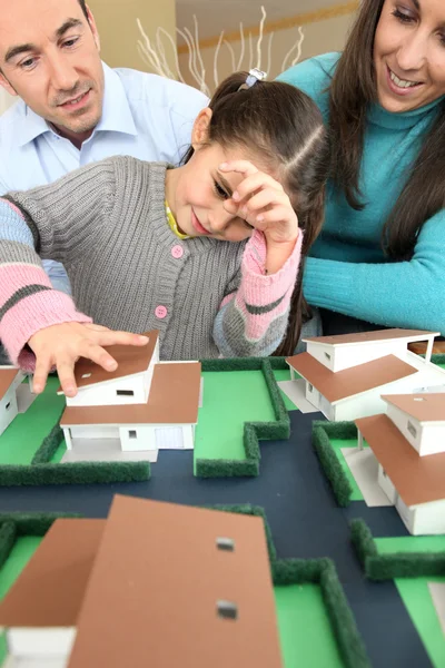 Familia joven mirando la casa modelo —  Fotos de Stock