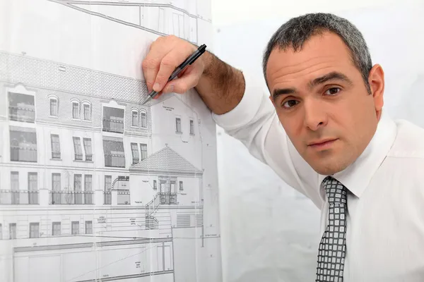 Arkitekt undersöker en blåkopia i detalj — Stockfoto