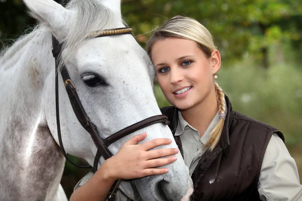Blonde vrouw met haar paard — Stockfoto