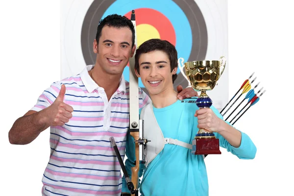 Proud team of archers posing with their trophy — Stock Photo, Image