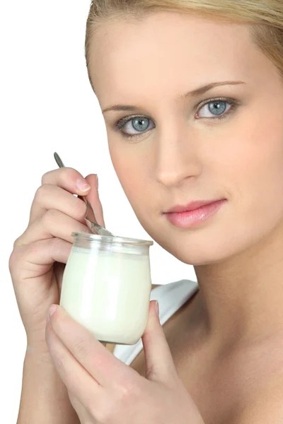 Junge Frau isst einen Joghurt — Stockfoto