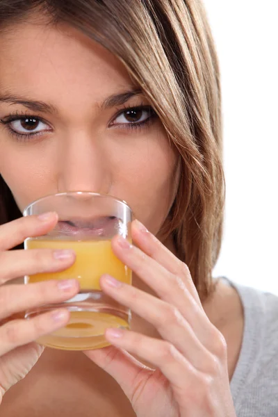 Mulher bebendo um copo de suco de laranja — Fotografia de Stock