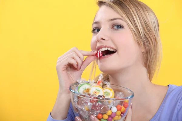 Жінка їсть цукерки — стокове фото