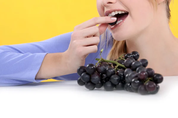Boca de mujer comiendo uvas — Foto de Stock