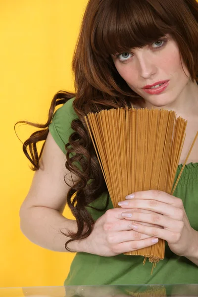 Mulher segurando espaguete não cozido — Fotografia de Stock