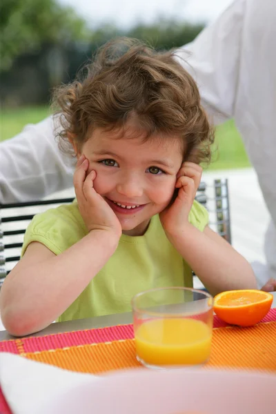 Kind trinkt eine Klasse frisch gepressten Orangensaft — Stockfoto