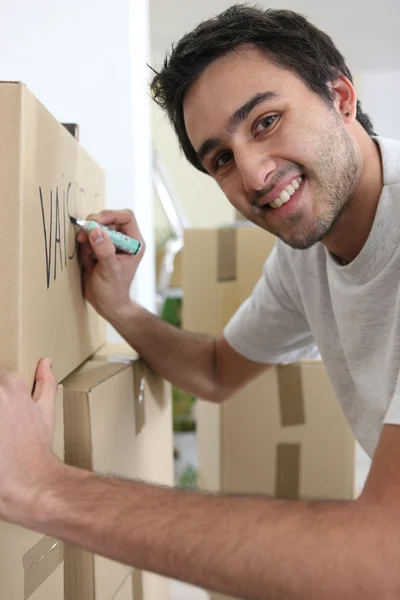 Jonge man schrijven over verhuisdozen — Stockfoto