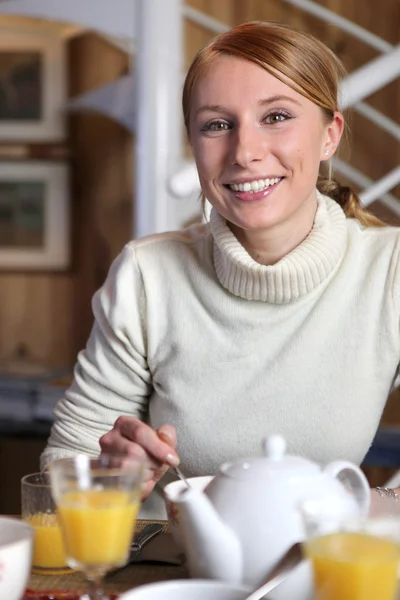Smiling woman at the breakfast table Royalty Free Stock Images