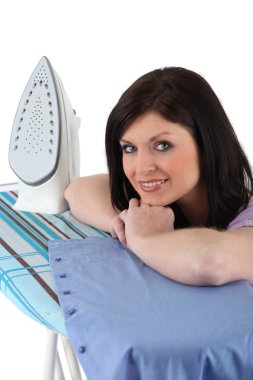 Woman ironing a shirt clipart