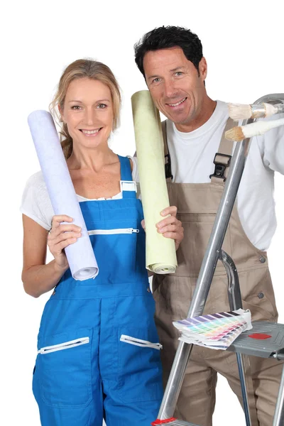 Homme et femme avec rouleaux de papier peint et escabeau — Photo