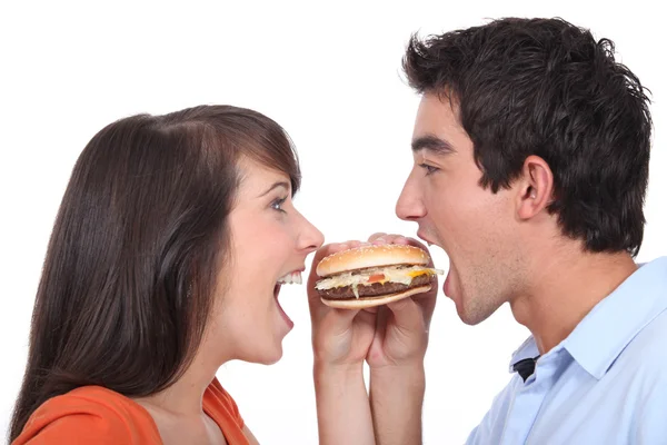 Giovane mangiare hamburger — Foto Stock