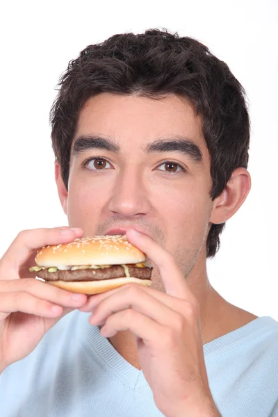 Člověk jíst cheesburger — Stock fotografie