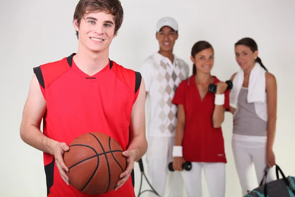 En basketspelare som poserar med andra idrottare — Stockfoto
