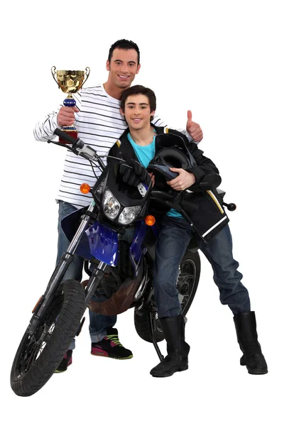 Padre e hijo con un trofeo de moto — Stockfoto