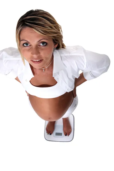 Pregnant woman on scales — Stock Photo, Image