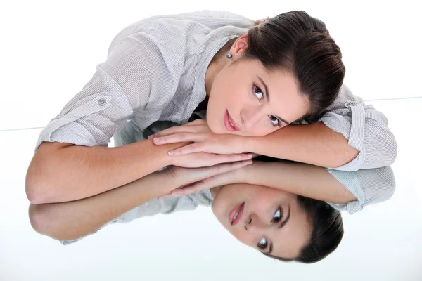 Woman leaning on a mirrored table — Stock Photo, Image