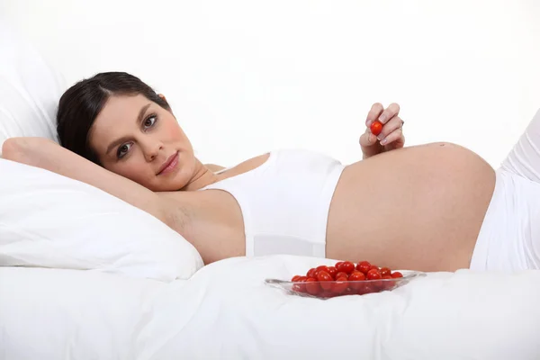 Těhotná žena s miskou rajčat — Stock fotografie