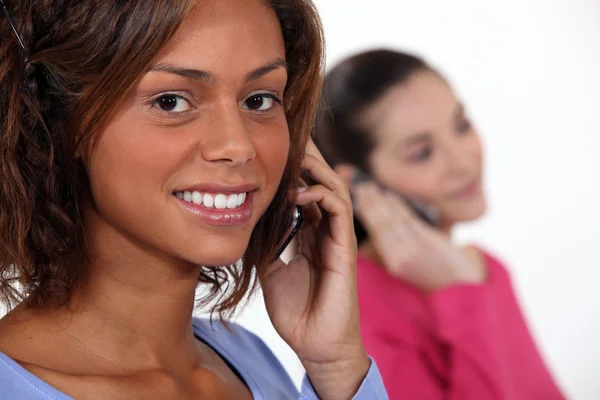 Fiatal nők beszélő-ra-uk mozgatható telefon — Stock Fotó