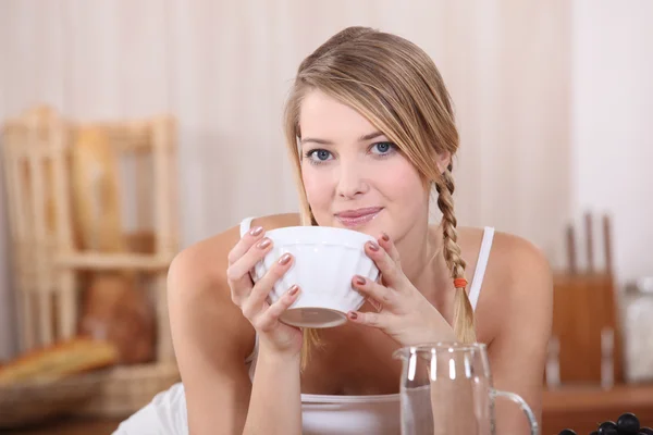 Blond drinking from bowl at breakfast — Stock Photo, Image