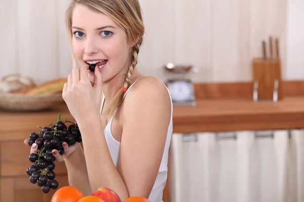 Blonde woman eating grapes — Stock Photo, Image