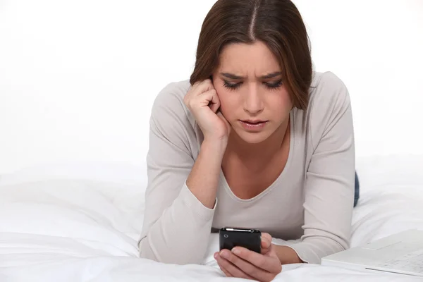 Mulher recebendo uma mensagem de texto perturbadora — Fotografia de Stock
