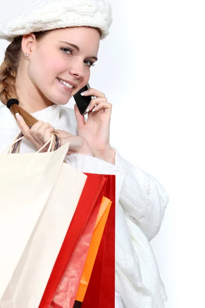 Genç kadın alışveriş torbaları holding ve cep telefonundan konuşuyor — Stok fotoğraf