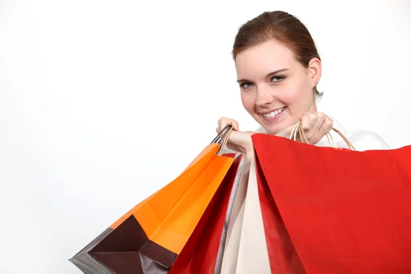 Mulher segurando inúmeros sacos de compras — Fotografia de Stock