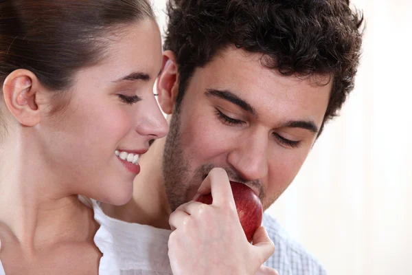 吃一个苹果的年轻男子和年轻女子 — 图库照片